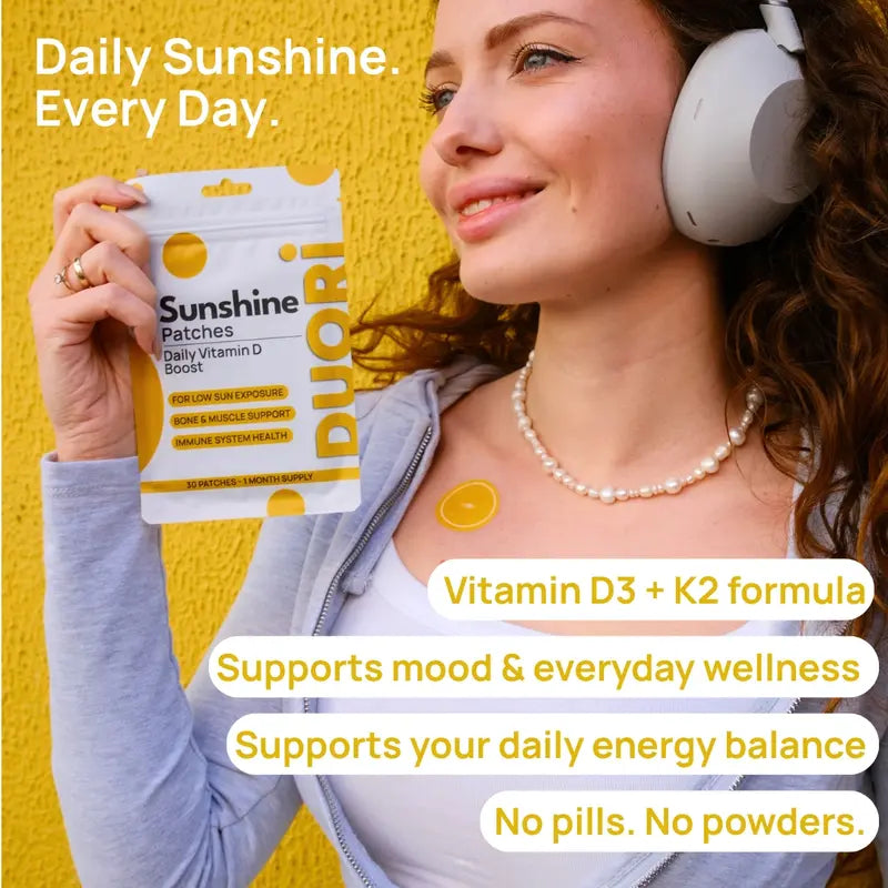 Woman wearing Duori Vitamin D3 K2 patch on chest while holding product, supporting energy, mood, and daily wellness